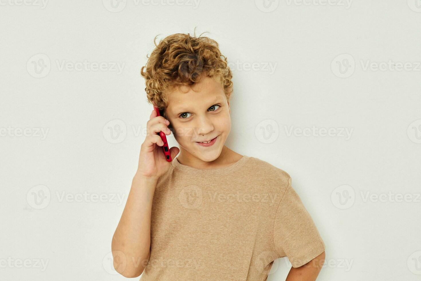 alegre linda chico con teléfono en manos posando tecnología foto