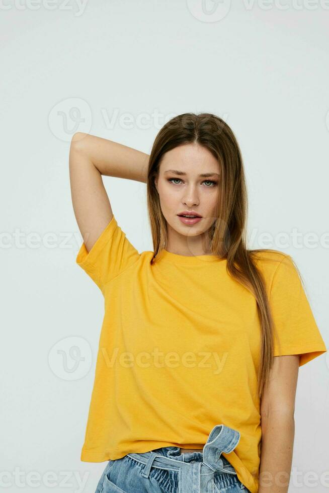 alegre mujer en un amarillo camiseta y mezclilla pantalones cortos juventud estilo ligero antecedentes foto