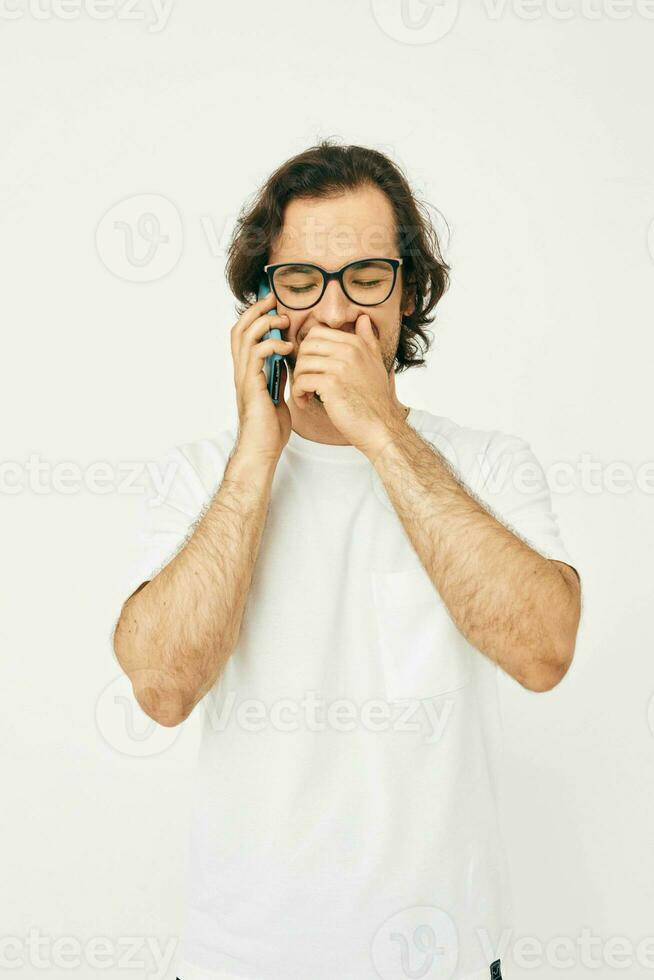 Cheerful man in a white T-shirt communication by phone isolated background photo