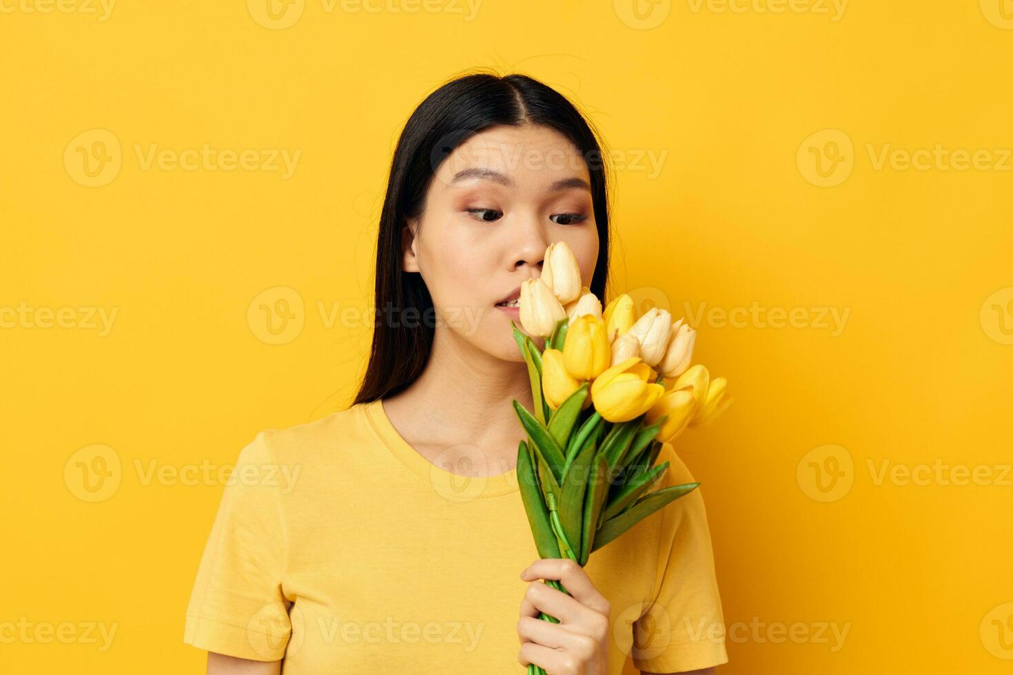 bonito morena en un amarillo camiseta camiseta con un ramo de flores de flores fiesta monocromo Disparo foto