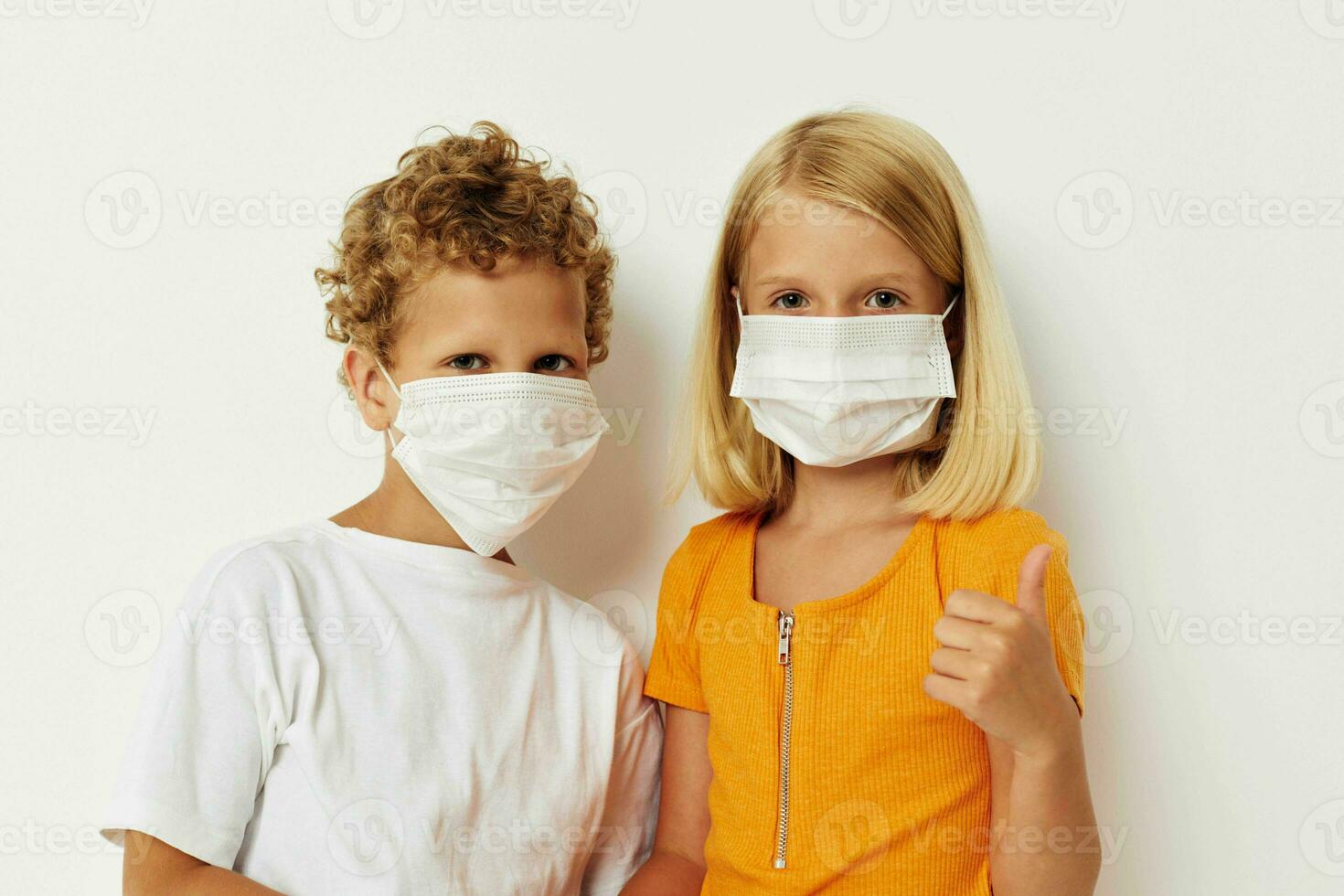 Portrait of cute children fun medical mask stand side by side close-up lifestyle unaltered photo