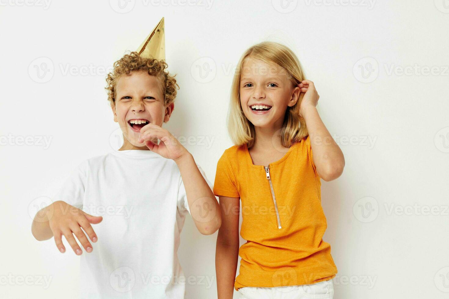 Boy and girl in multicolored caps birthday holiday emotion light background photo