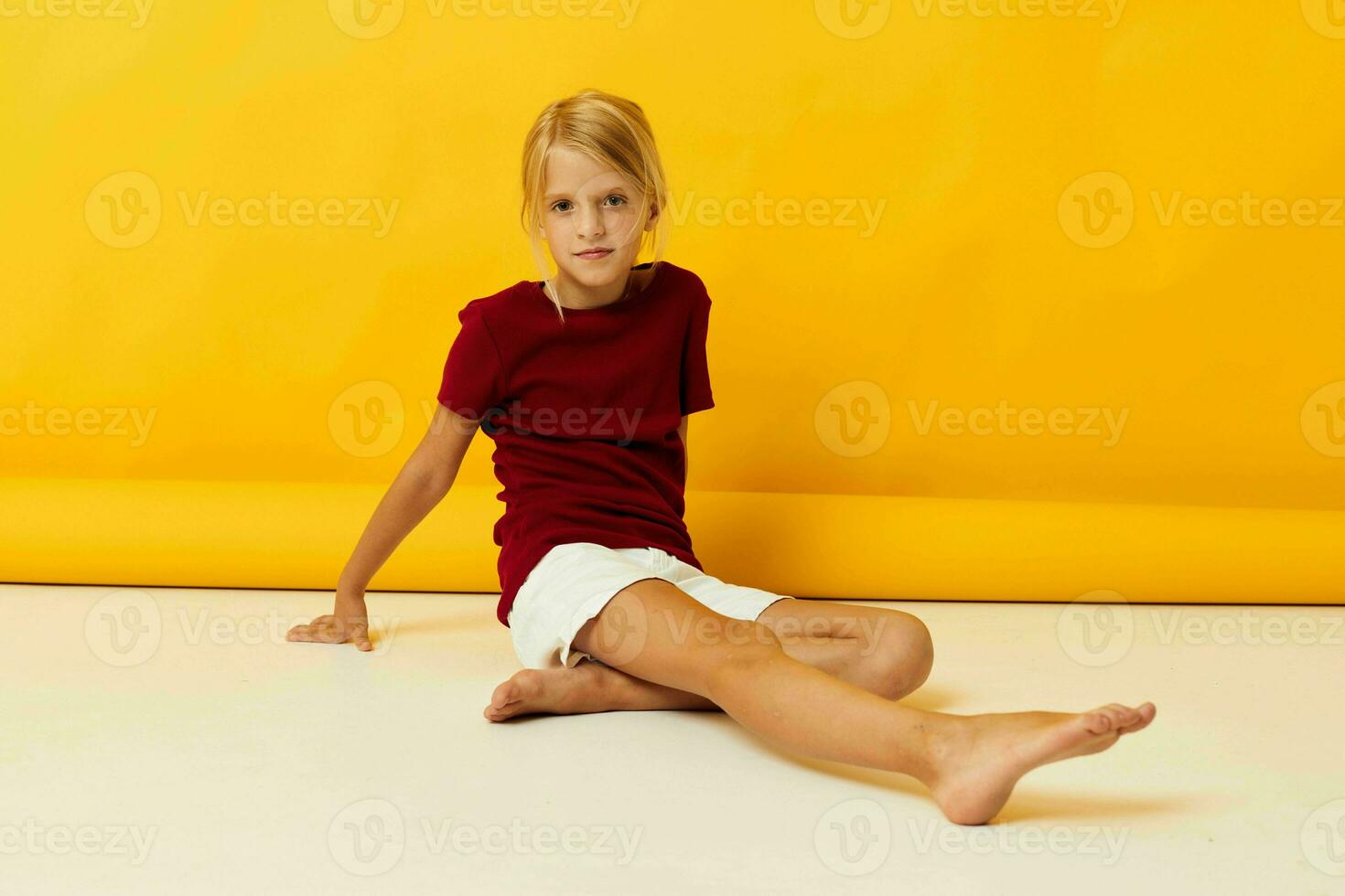 Girl sitting on the floor posing yellow background photo