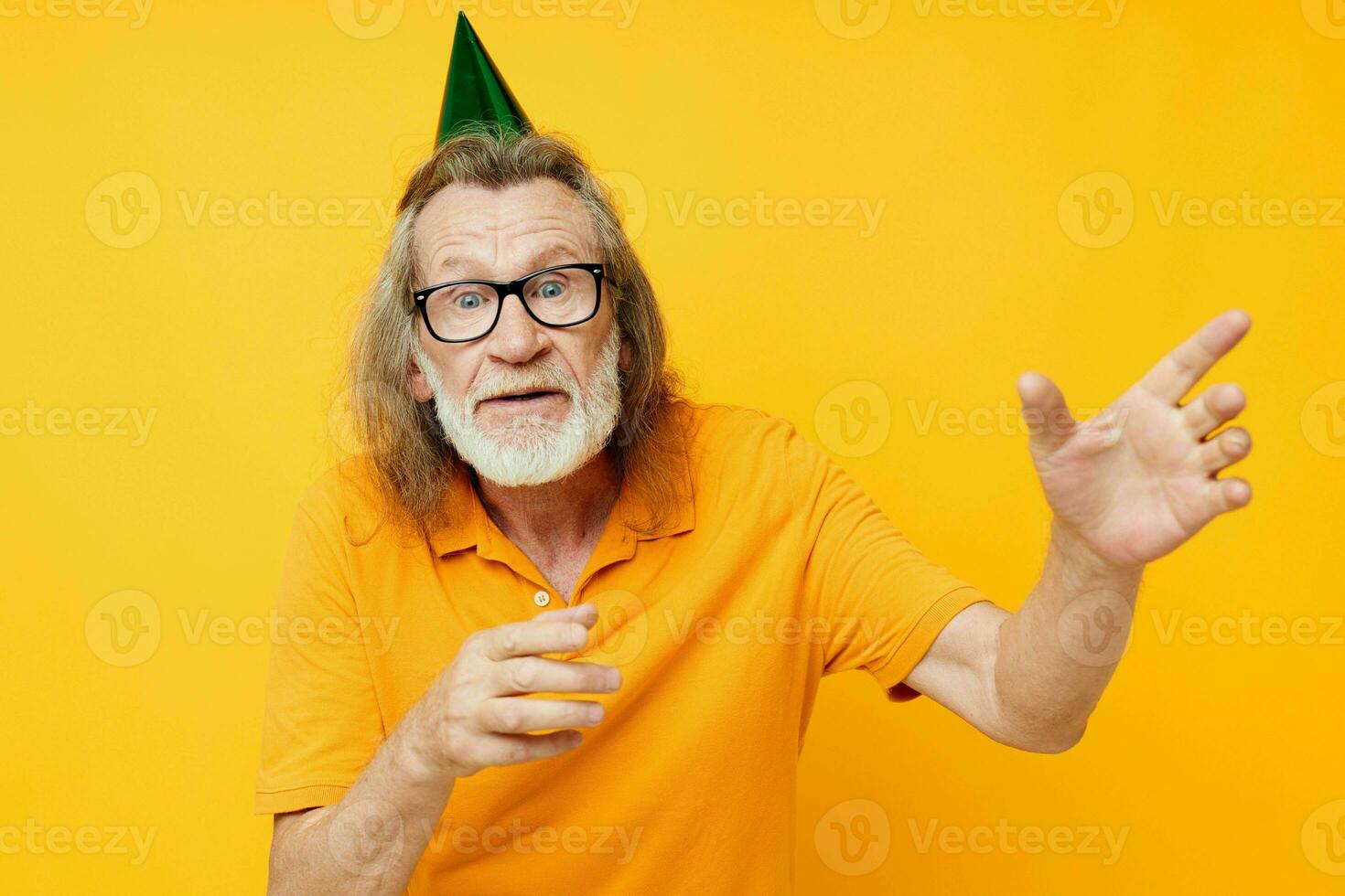 Portrait elderly man in a yellow t-shirt with a cap on his head fun cropped view photo