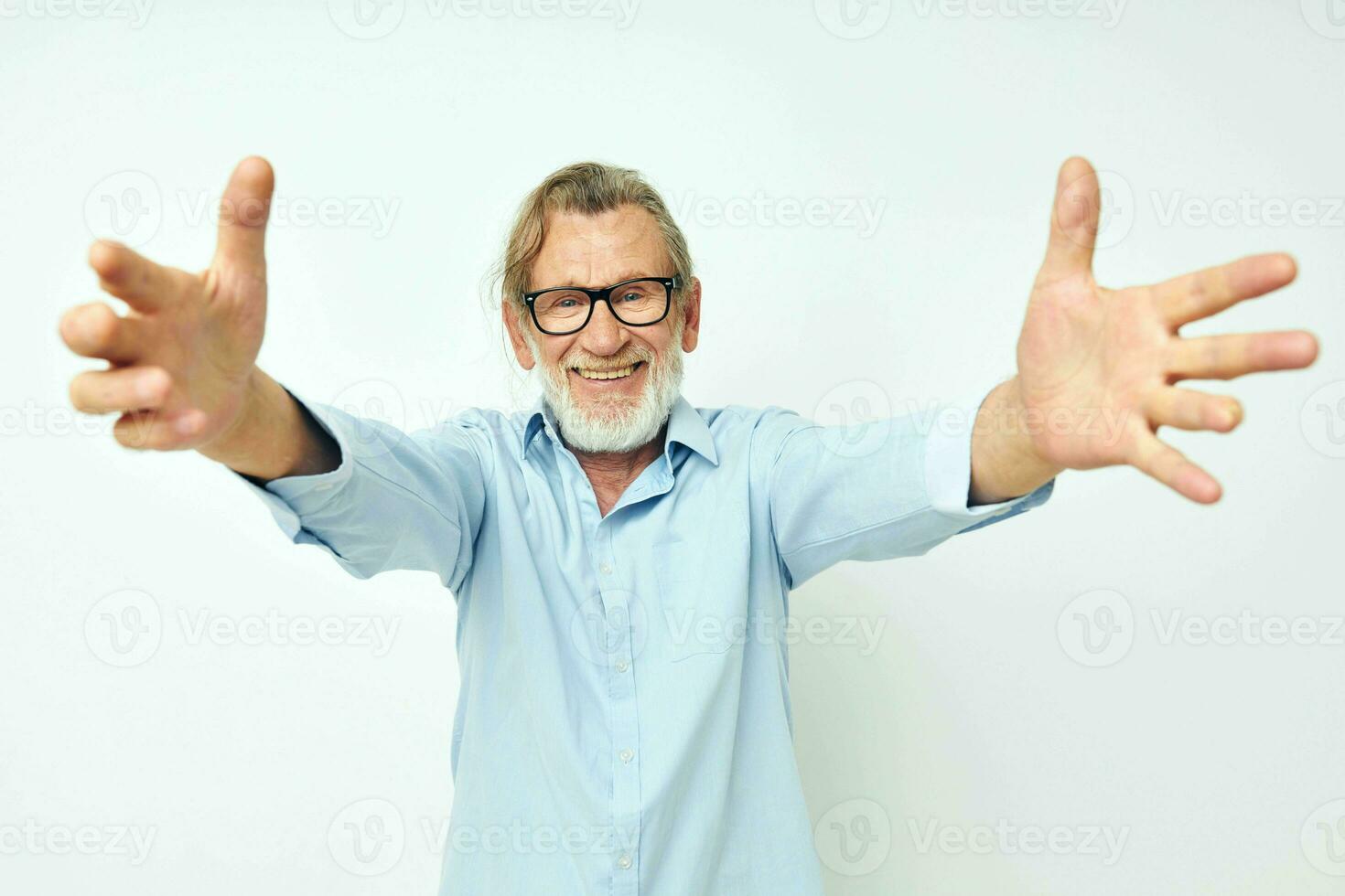 old man in blue shirts gestures with his hands isolated background photo