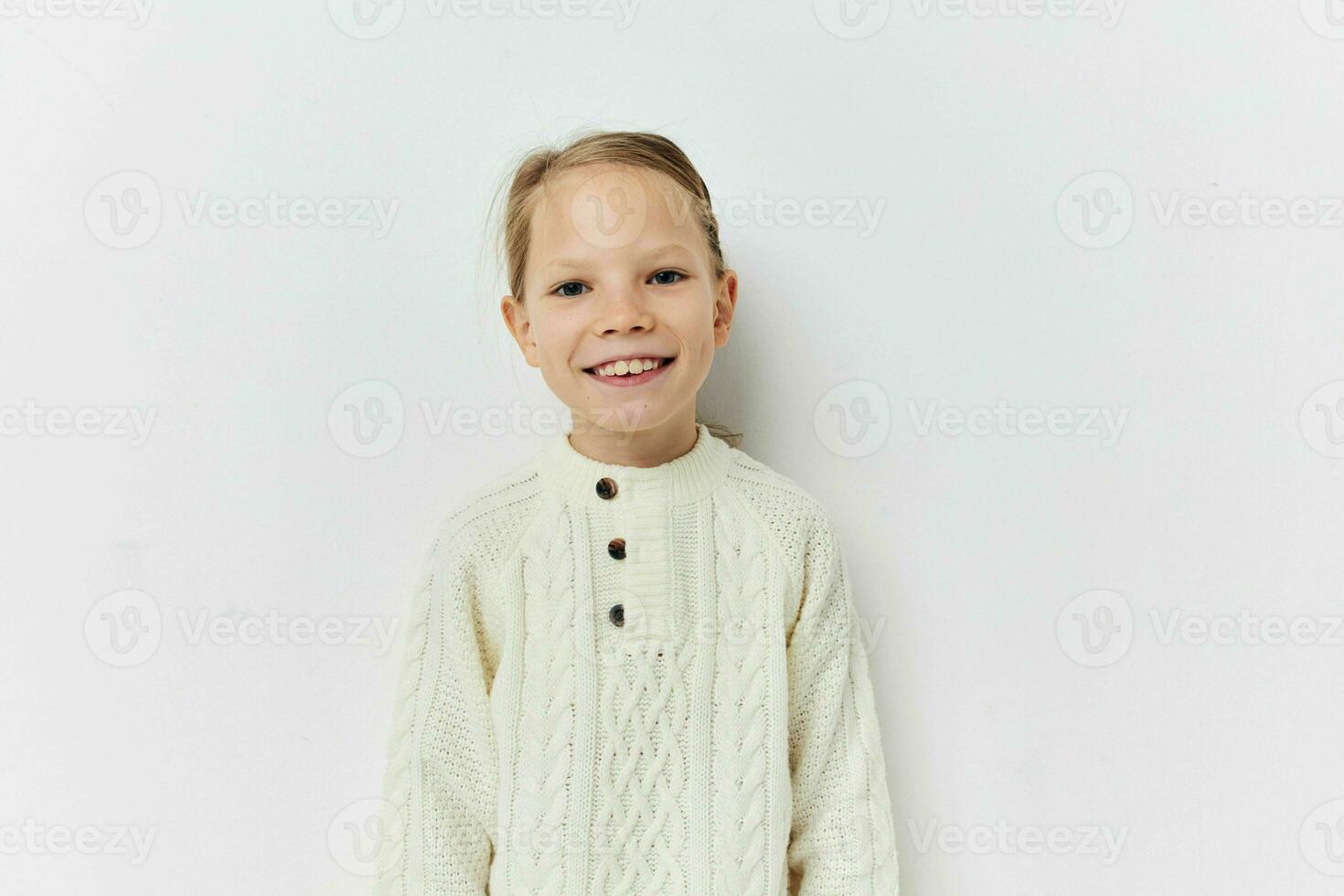 little girl white sweater hand gestures light background photo