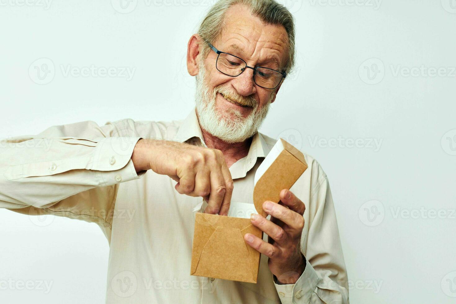 Old man with a box in his hands in studio alone photo