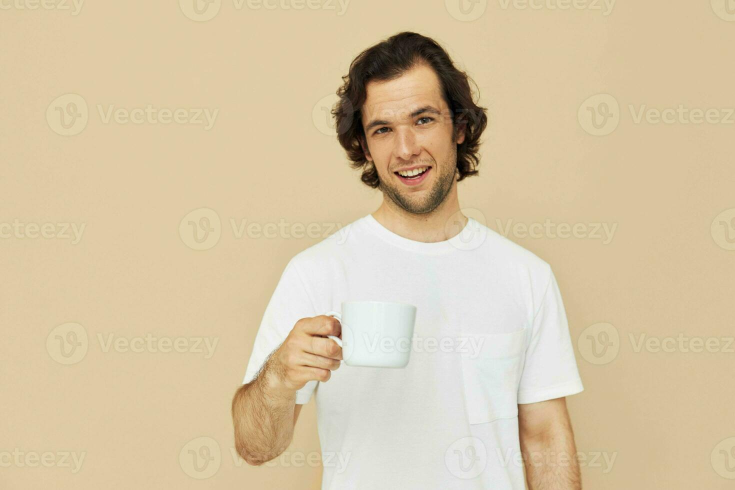 Cheerful man in a white T-shirt with a mug in hand Lifestyle unaltered photo