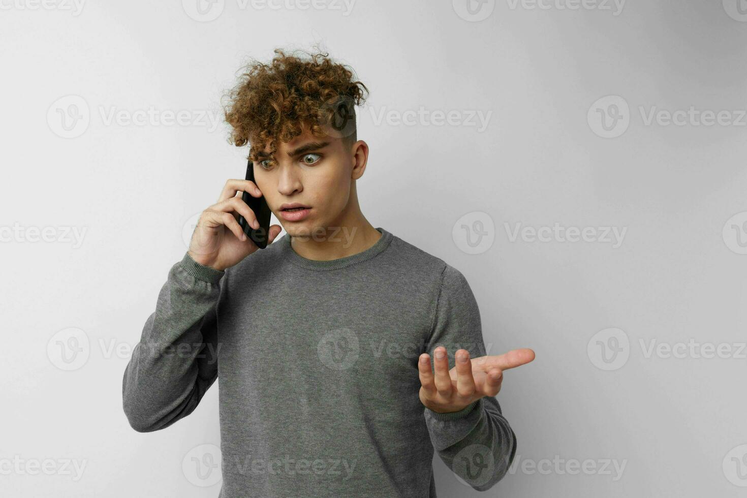 hermoso chico hablando en el teléfono posando emociones aislado antecedentes foto