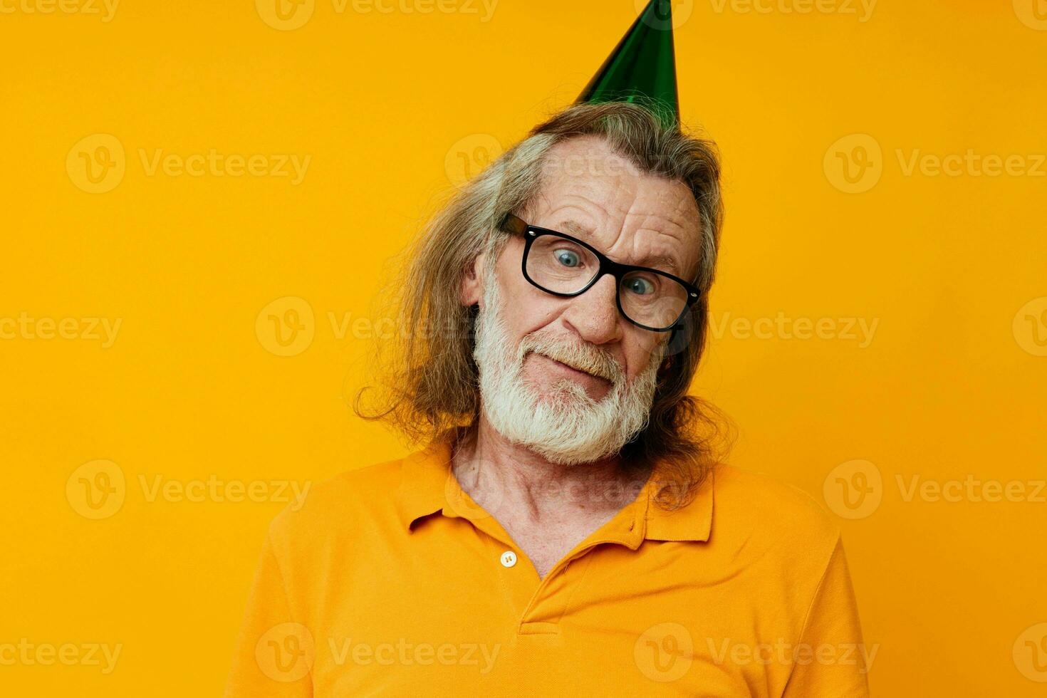 Senior grey-haired man fun birthday cap on the head isolated background photo