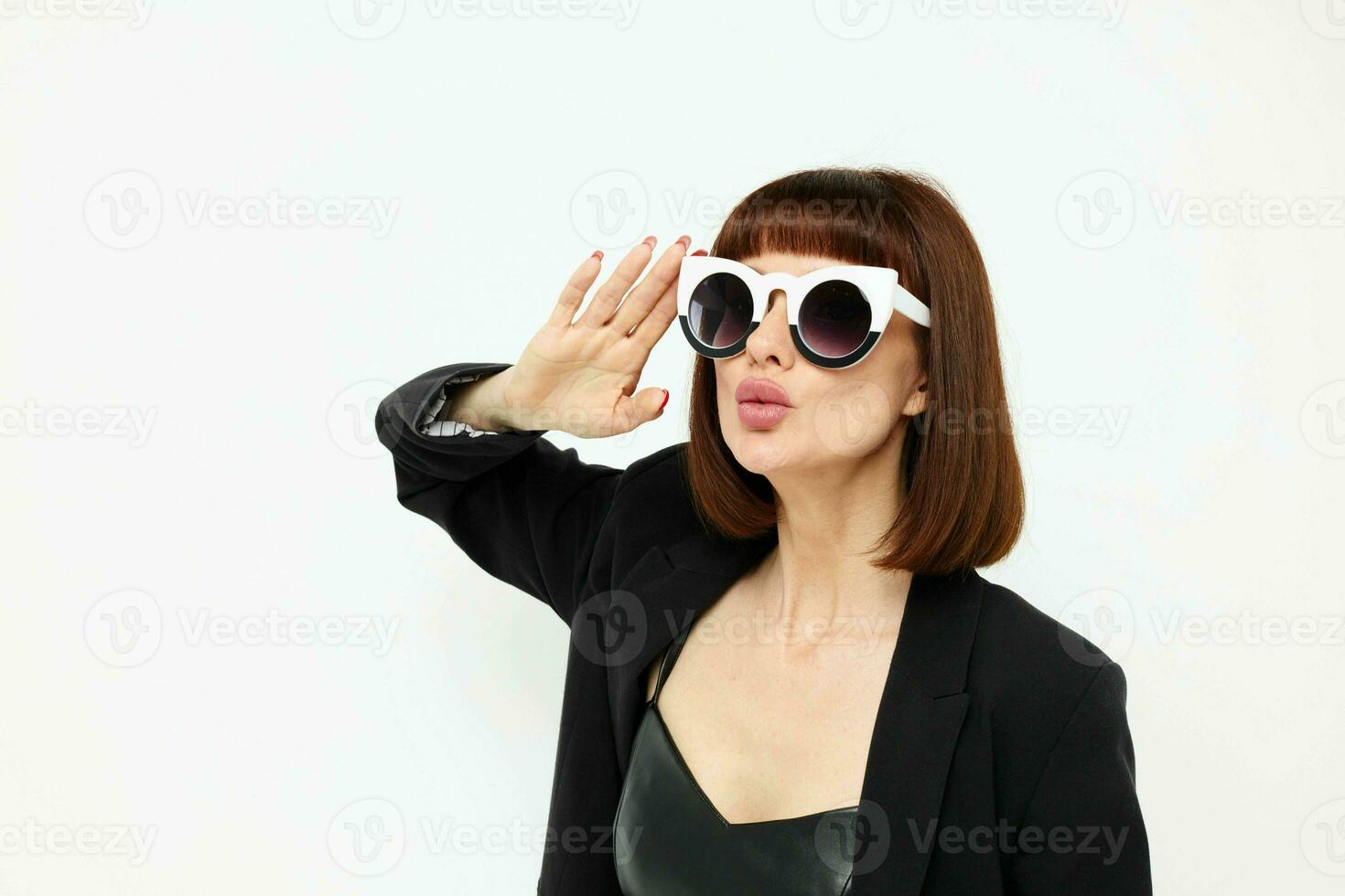 photo pretty woman in a black jacket red nail polish stylish sunglasses light background