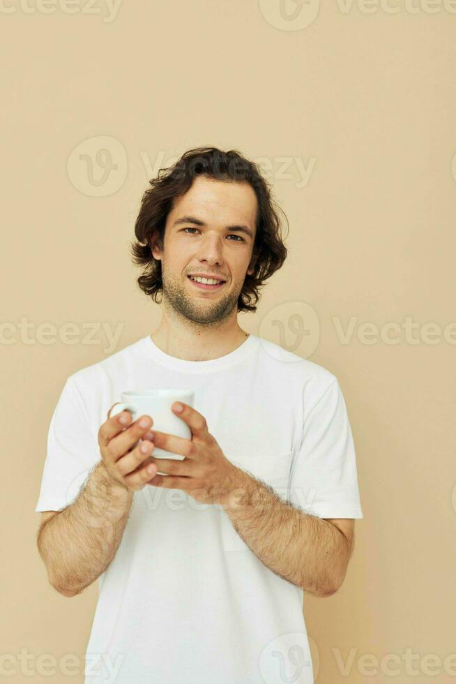 man in a white T-shirt with a mug in hand isolated background photo