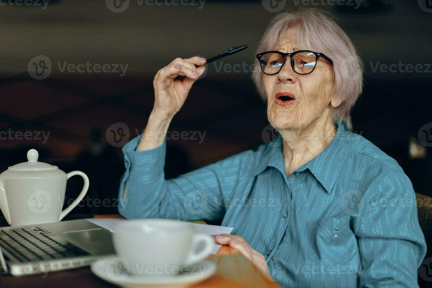 Portrait of an elderly woman documents work sheet of paper and pen Retired woman chatting unaltered photo