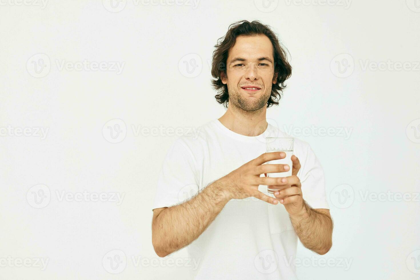 atractivo hombre en un blanco camiseta vaso de agua aislado antecedentes foto