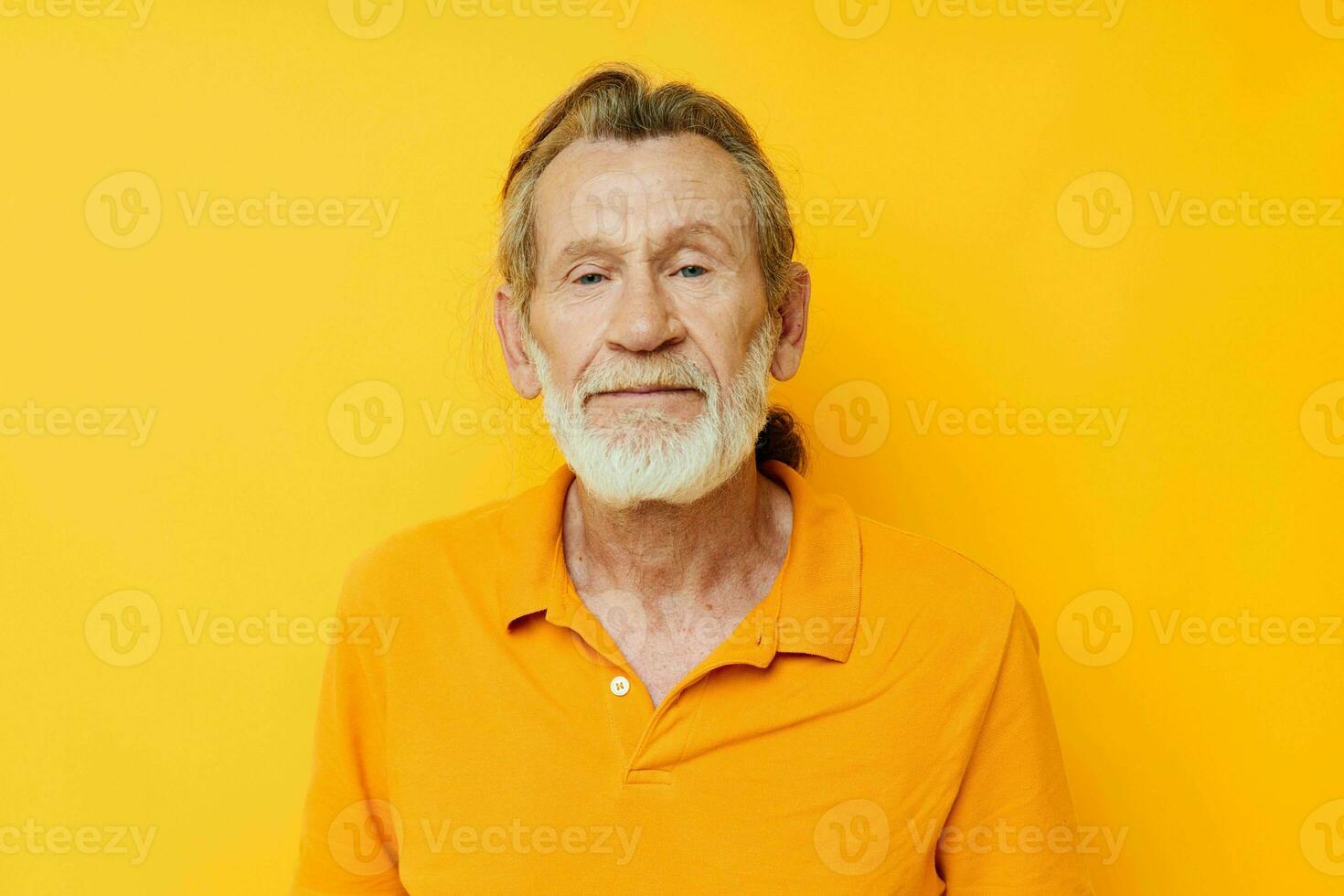 Portrait of happy senior man yellow shirt posing emotions yellow background photo