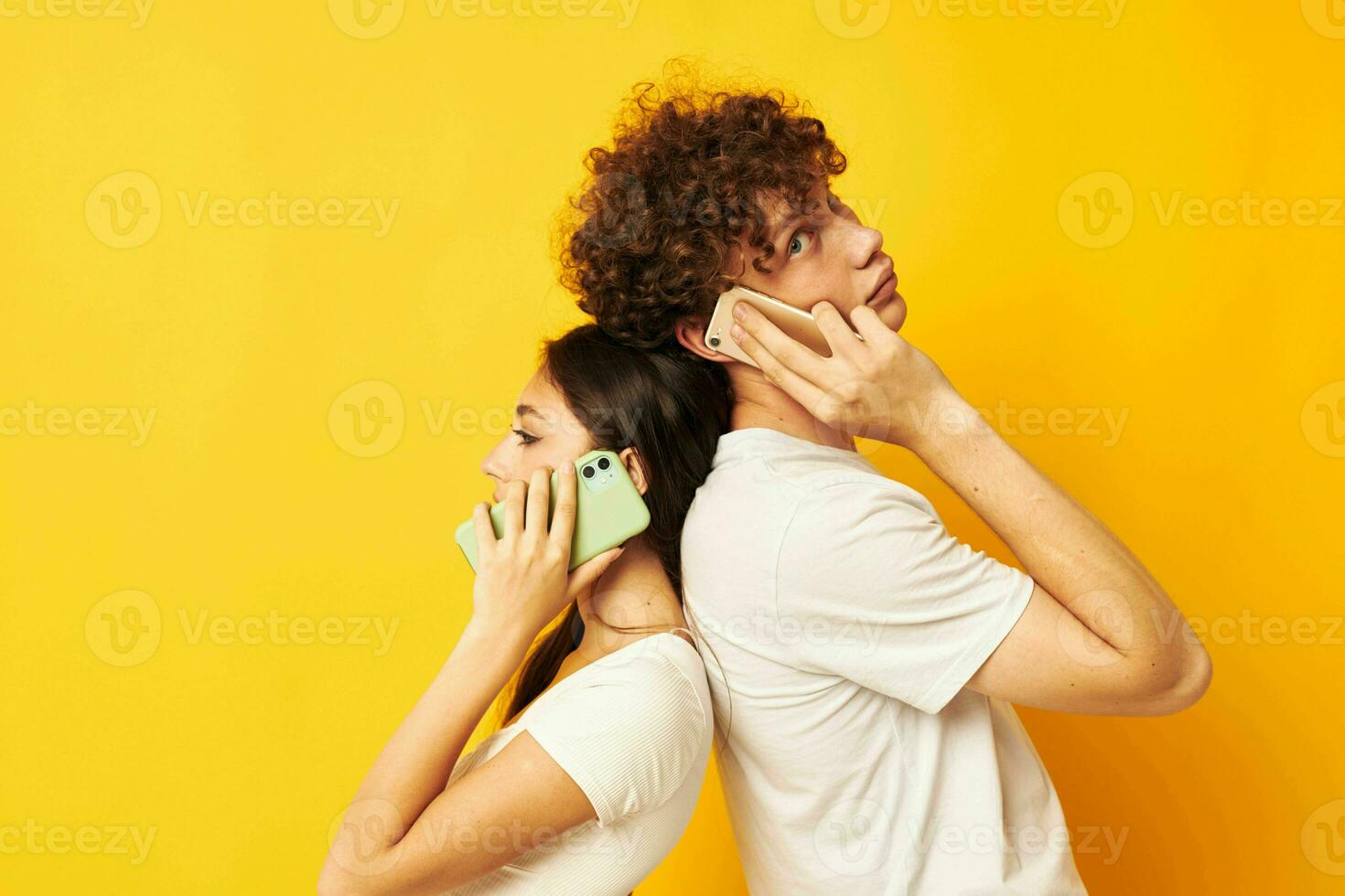 un chico y un niña estar con su espaldas a cada otro hablando en el teléfono foto