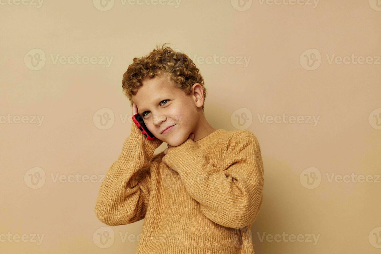 little boy in a sweater talking on the phone photo