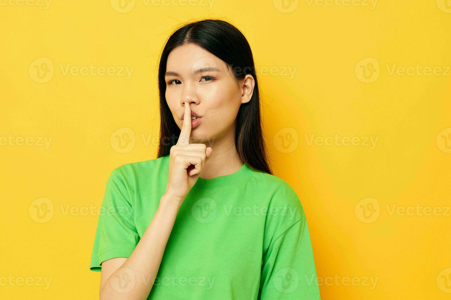 Charming young Asian woman in green t-shirts gestures with his hands emotions studio model unaltered photo