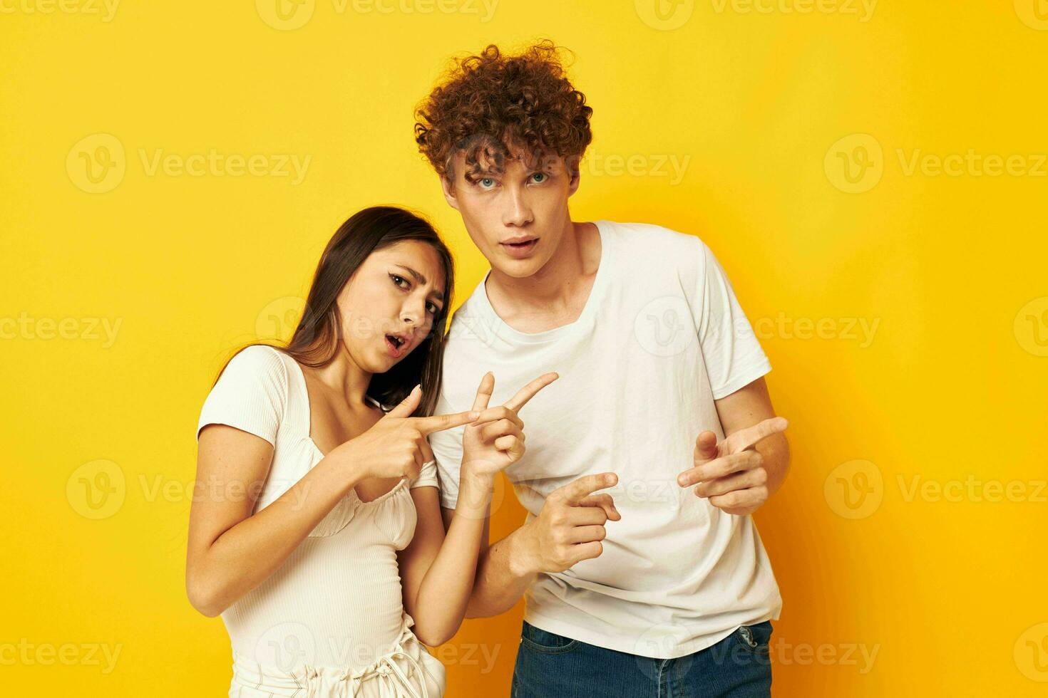 cute young couple standing side by side in white t-shirts posing Lifestyle unaltered photo