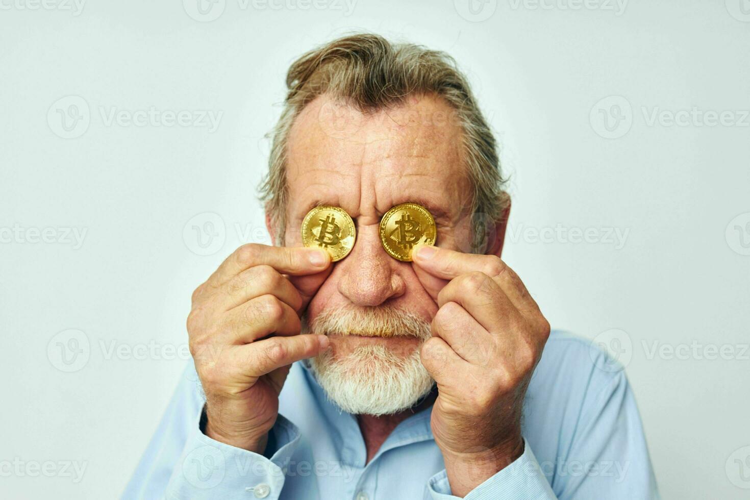 Senior grey-haired man cryptocurrency bitcoin face close up investment light background photo