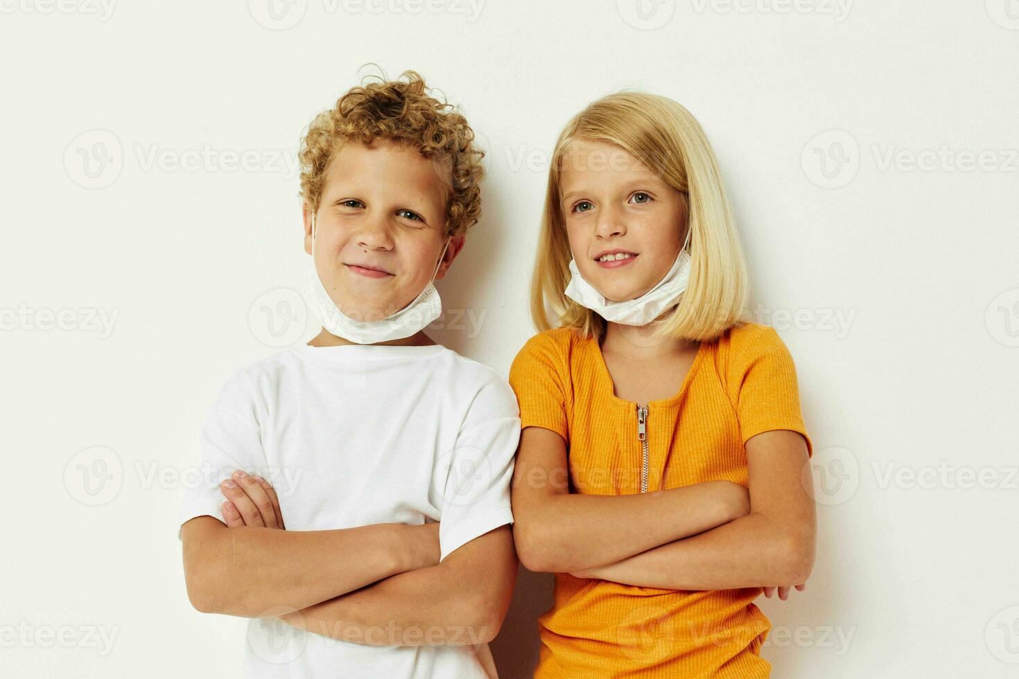 Boy and girl fun medical mask stand side by side close-up light background photo