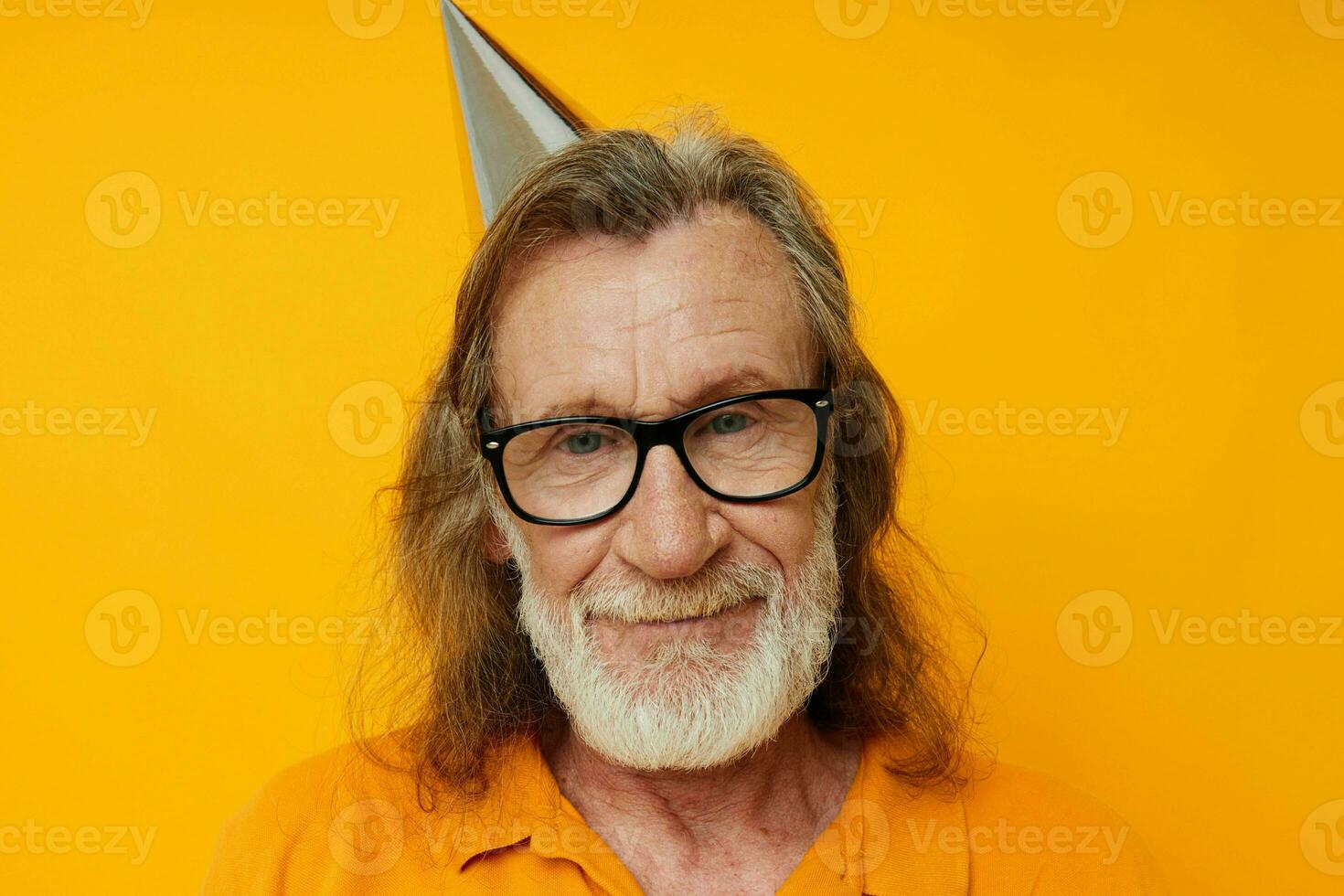 cheerful elderly man in glasses with a cap on his head yellow background photo