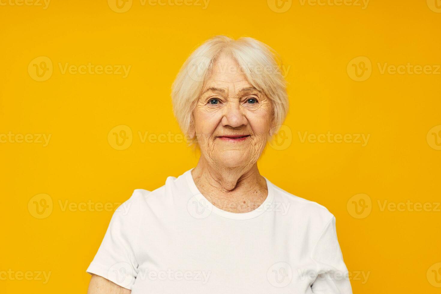 Photo of retired old lady in white t-shirt posing fun yellow background