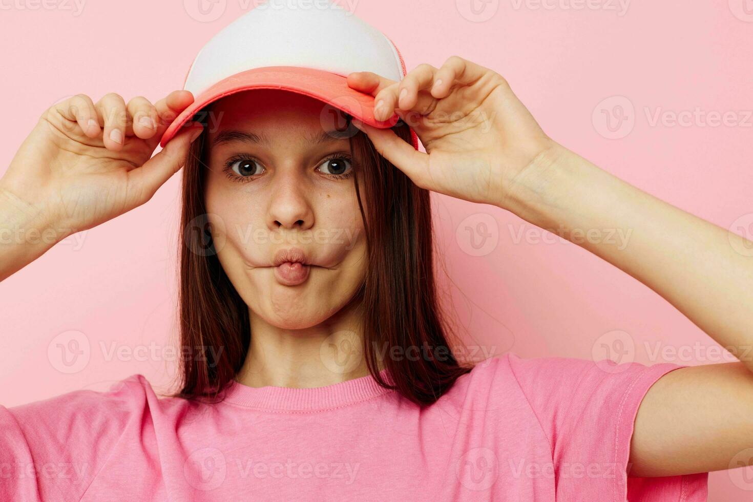young girl in a pink t-shirt with a cap on her head casual wear photo