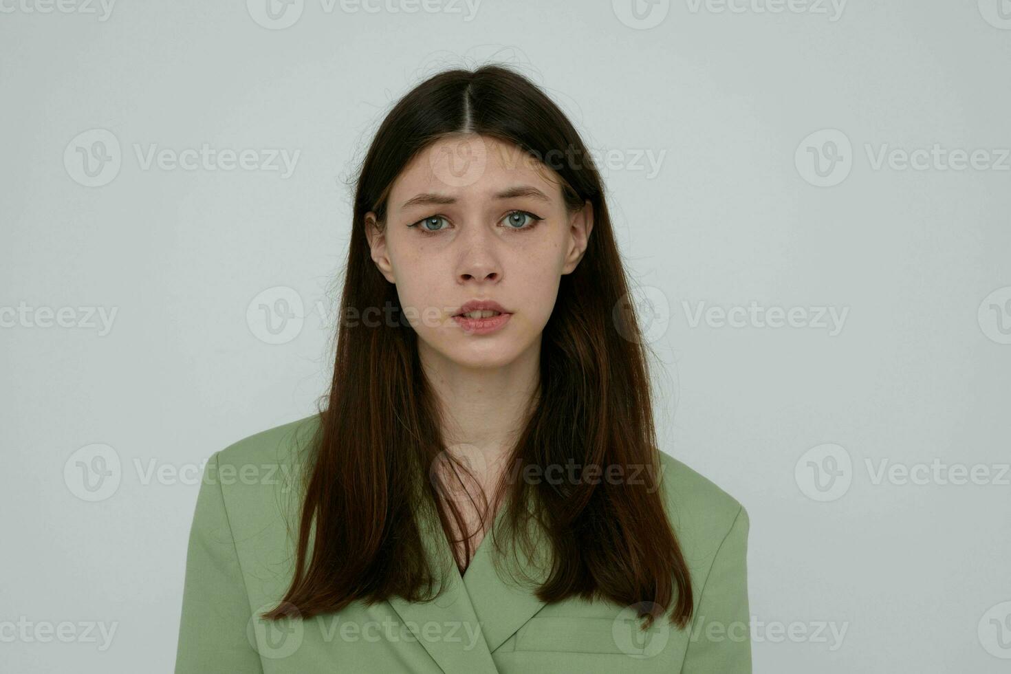 brunette in green jacket posing emotions light background photo