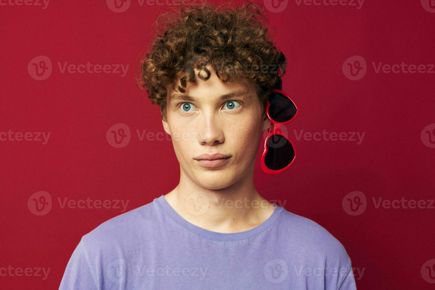 cute red-haired guy guy in a purple t-shirt with sunglasses posing Lifestyle photo