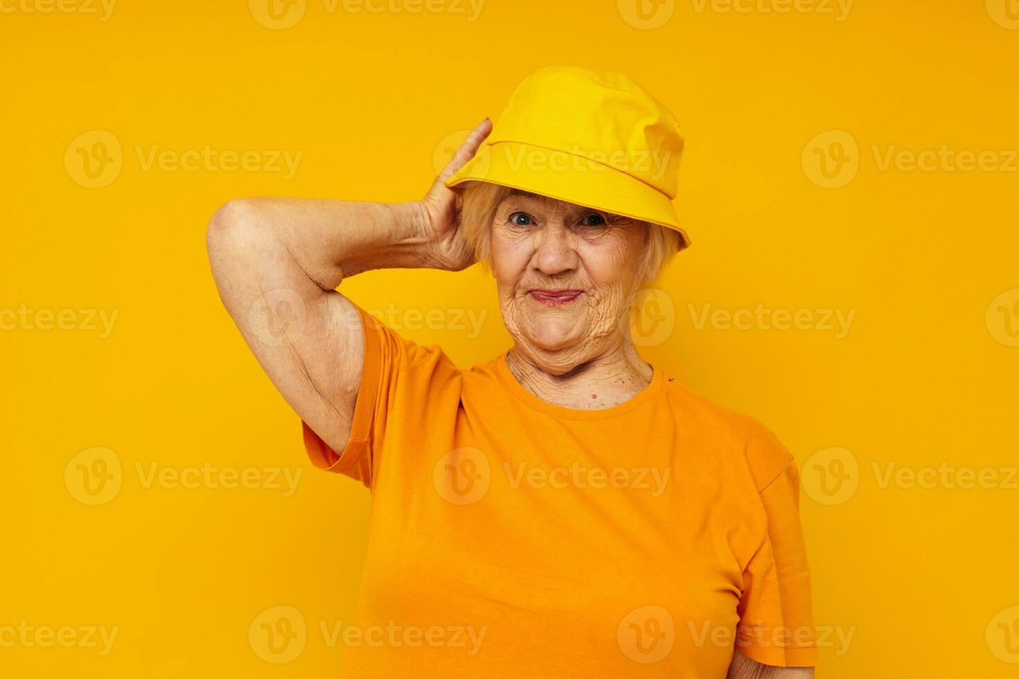 smiling elderly woman happy lifestyle in a yellow headdress yellow background photo