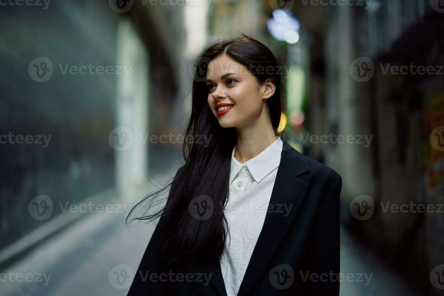 Fashion woman smile with teeth portrait tourist in stylish clothes in jacket with red lips walking down narrow city street flying hair, travel, French style, cinematic color, retro vintage style. photo