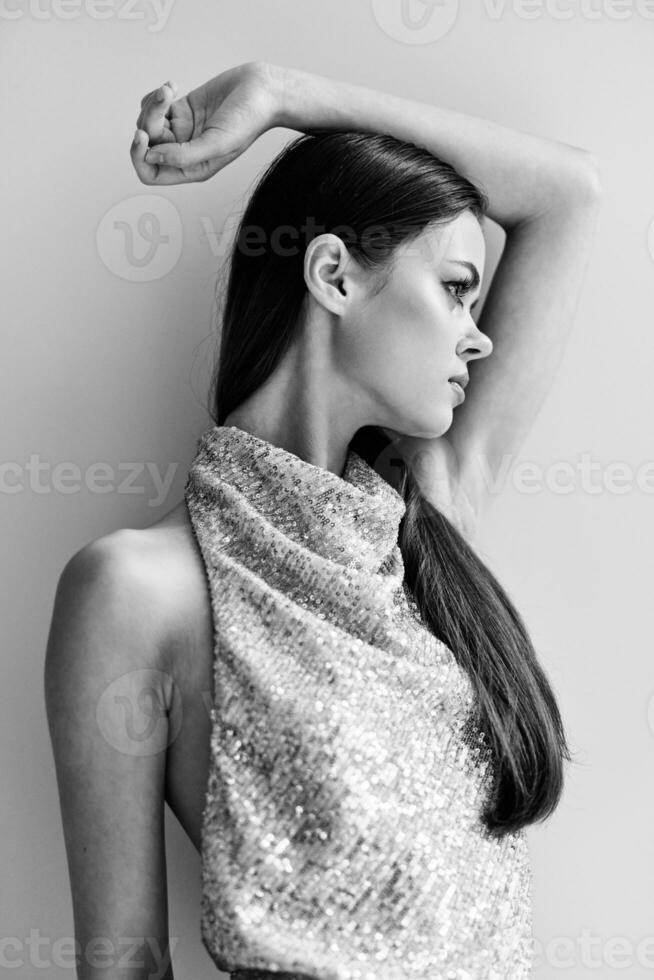 Black and white portrait of a stylish woman in an evening dress with glitter eye makeup, disco style party photo