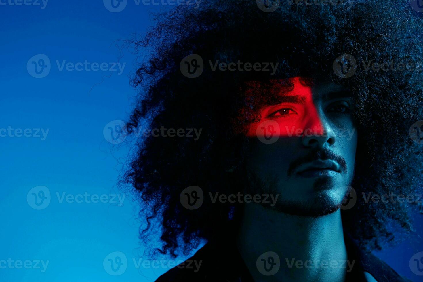 Fashion portrait of a man with curly hair on a blue background, multinational, colored light, trendy, modern concept. photo