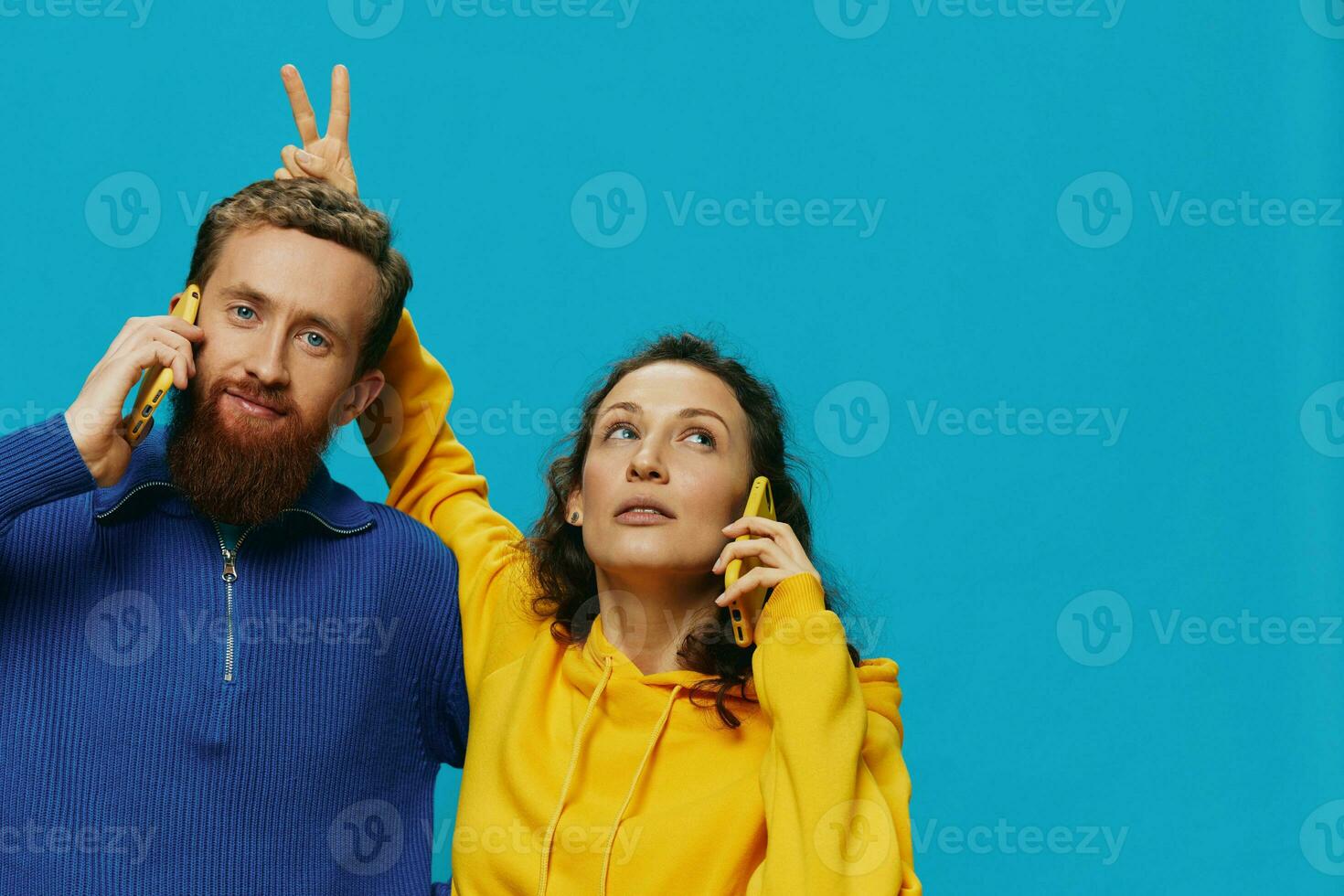 Woman and man cheerful couple with phones in their hands crooked smile cheerful, on blue background. The concept of real family relationships, talking on the phone, work online. photo