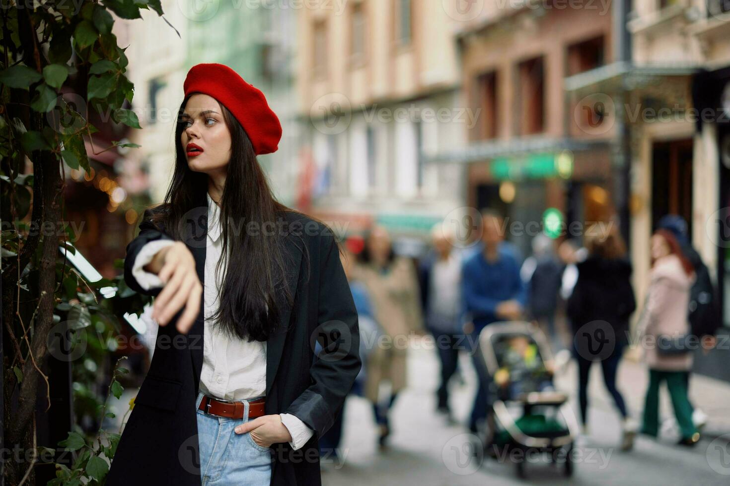 Woman fashion model walks on the street in the city center among the crowd in a jacket and red beret and jeans, cinematic french fashion style clothing, travel to istanbul photo