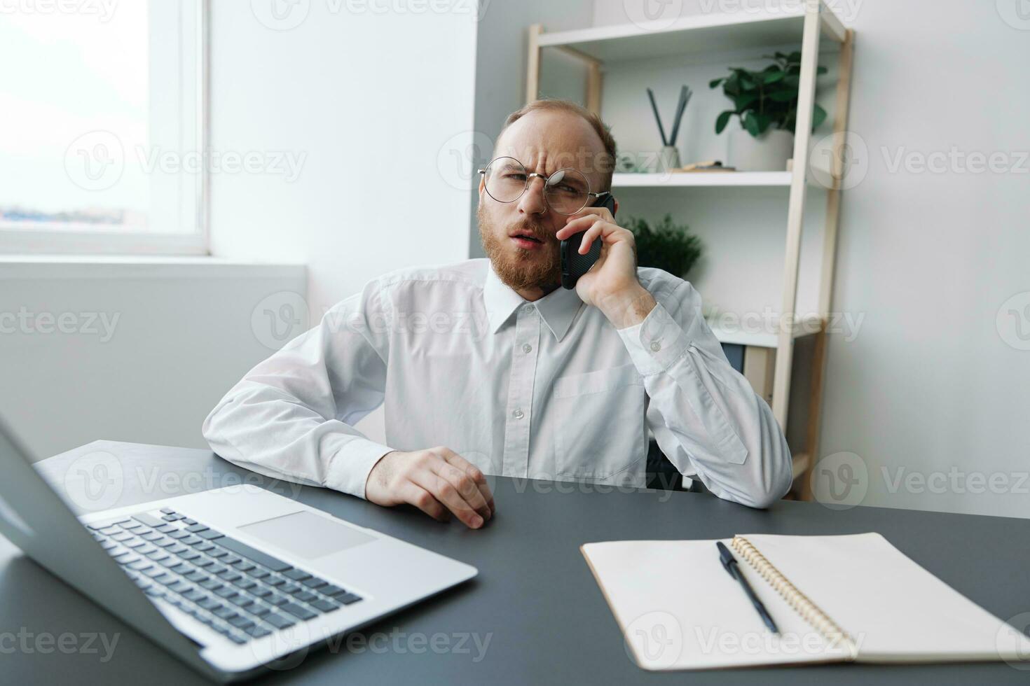 A man in a wheelchair a businessman with tattoos in the office works, talking on the phone screaming and angry, integration into society, the concept of working a person with disabilities photo