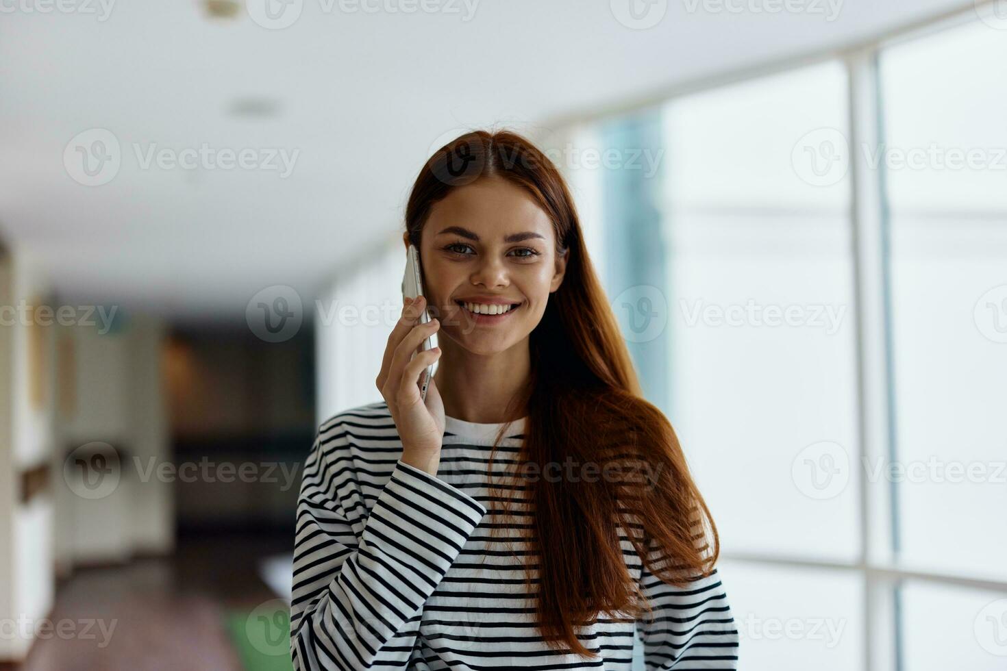 contento mujer sonrisa con dientes hablando en el teléfono retrato, hablando en un inteligente teléfono terminado el Internet foto