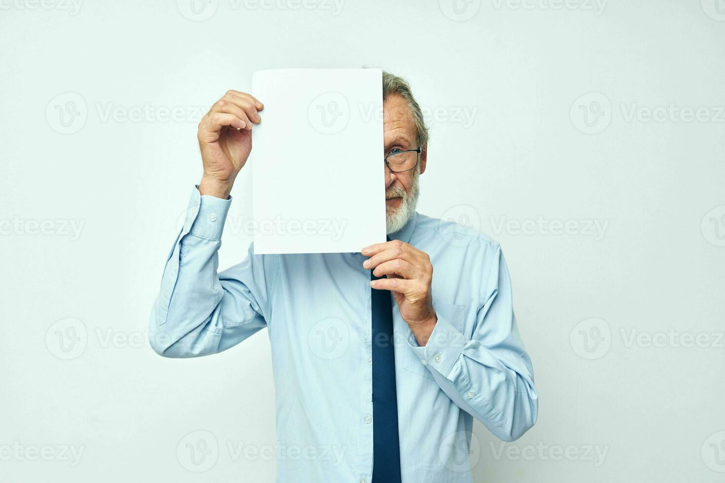 Portrait of happy senior man holding documents with a sheet of paper light background photo