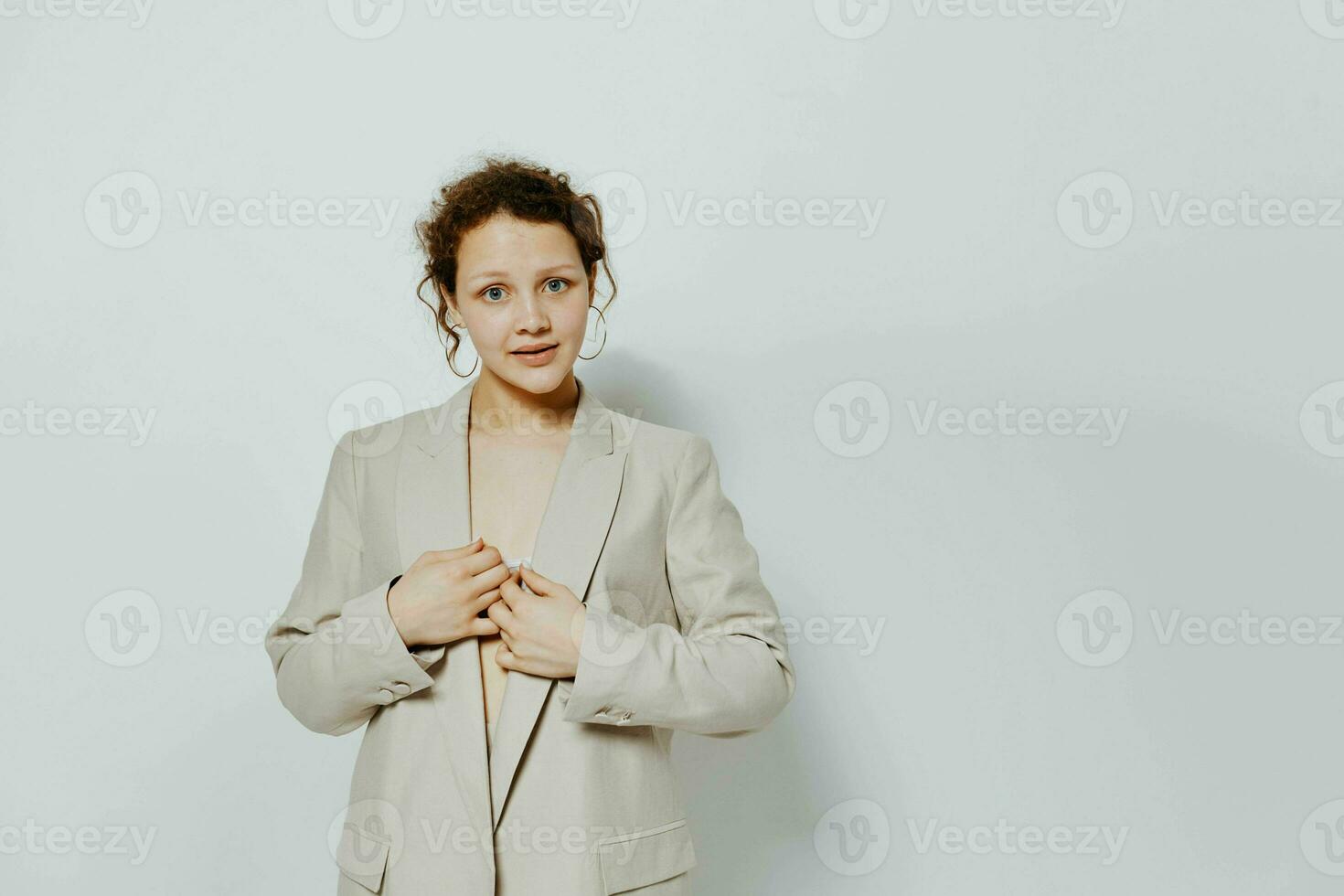 portrait of a young woman classic suit fashion posing fun light background unaltered photo
