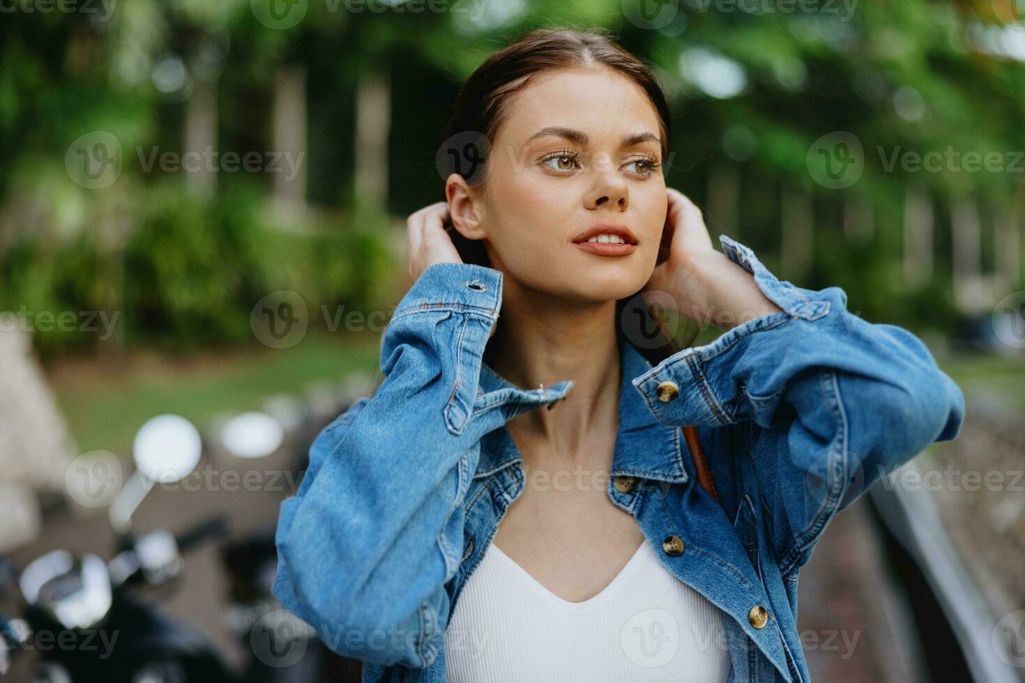 Portrait of a woman brunette smile with teeth walking outside against a backdrop of palm trees in the tropics, summer vacations and outdoor recreation, the carefree lifestyle of a freelance student. photo