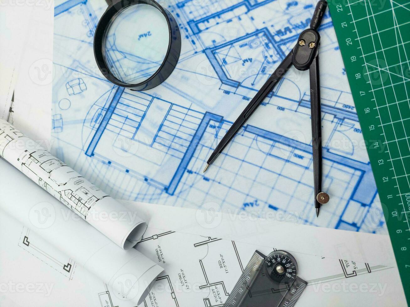 Architect engineer office desk. Blueprint plans and house model with ruler, compass, and magnifier glass photo