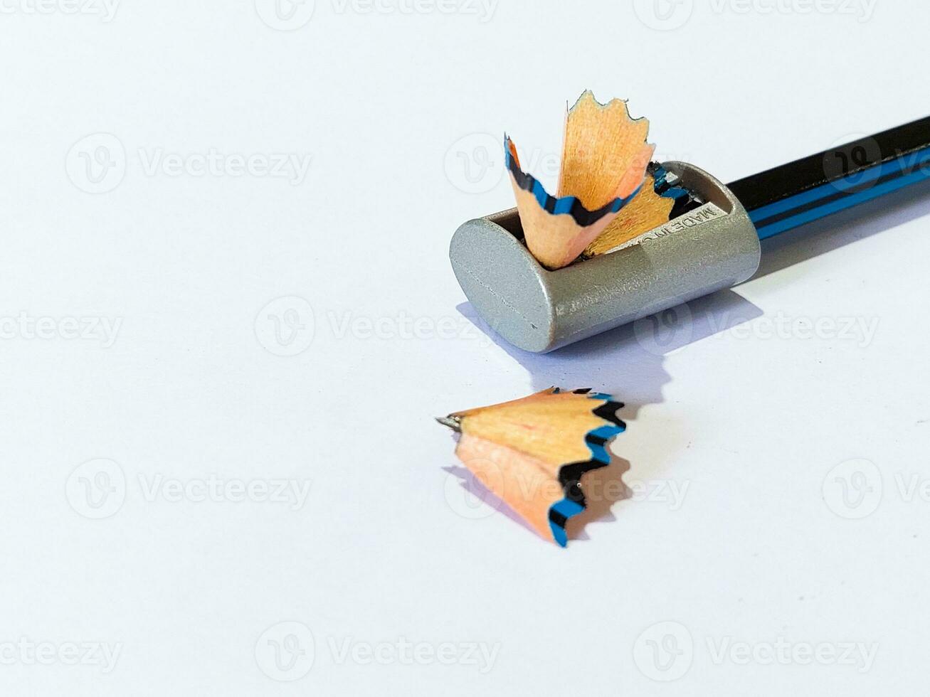 Pencil with sharpening shavings on white background photo