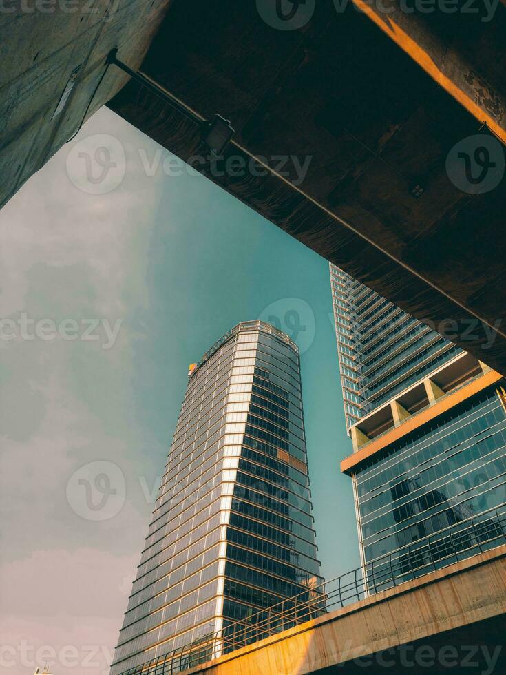 Bottom view of modern skyscrapers in business district against blue sky photo