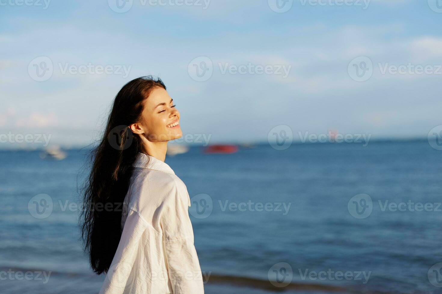 Woman smile freedom on vacation walking on the beach by the ocean in Bali sunset, happy travel and vacation, sunset light photo