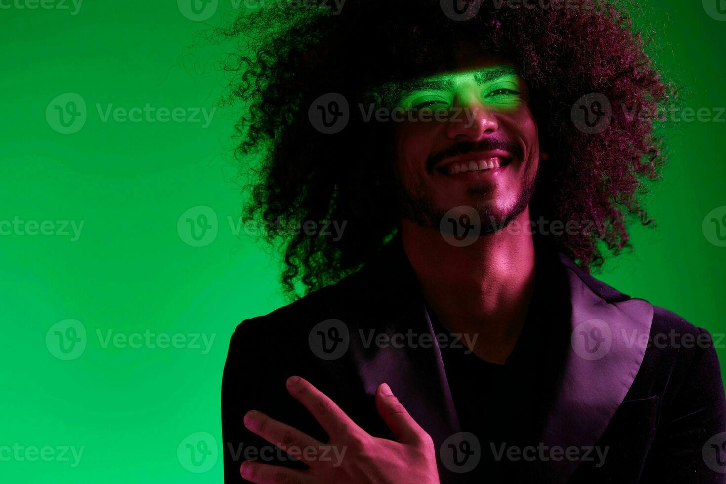 Portrait of a stylish man in a jacket on a green background multinational, color light, trend photo