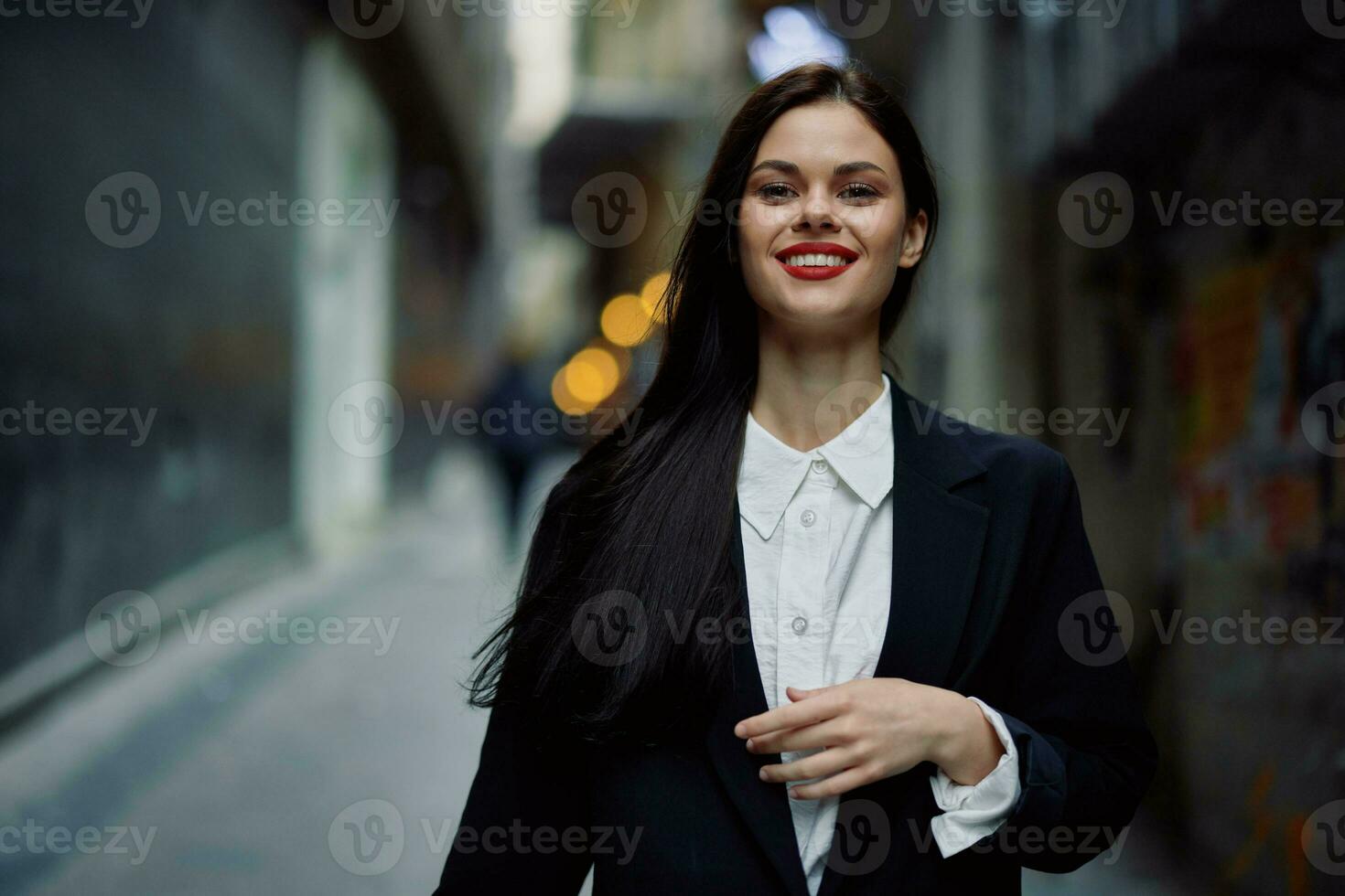 Moda mujer sonrisa con dientes retrato turista en elegante ropa en chaqueta con rojo labios caminando abajo estrecho ciudad calle volador cabello, viajar, francés estilo, cinematográfico color, retro Clásico estilo. foto