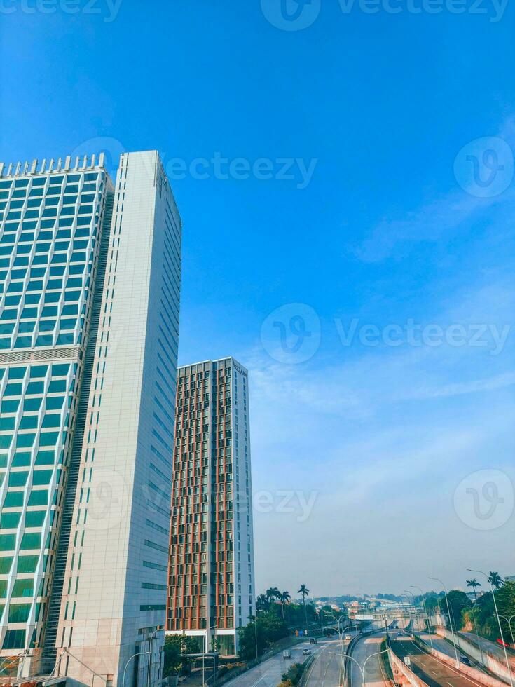 A modern office building with clear blue sky with street view photo