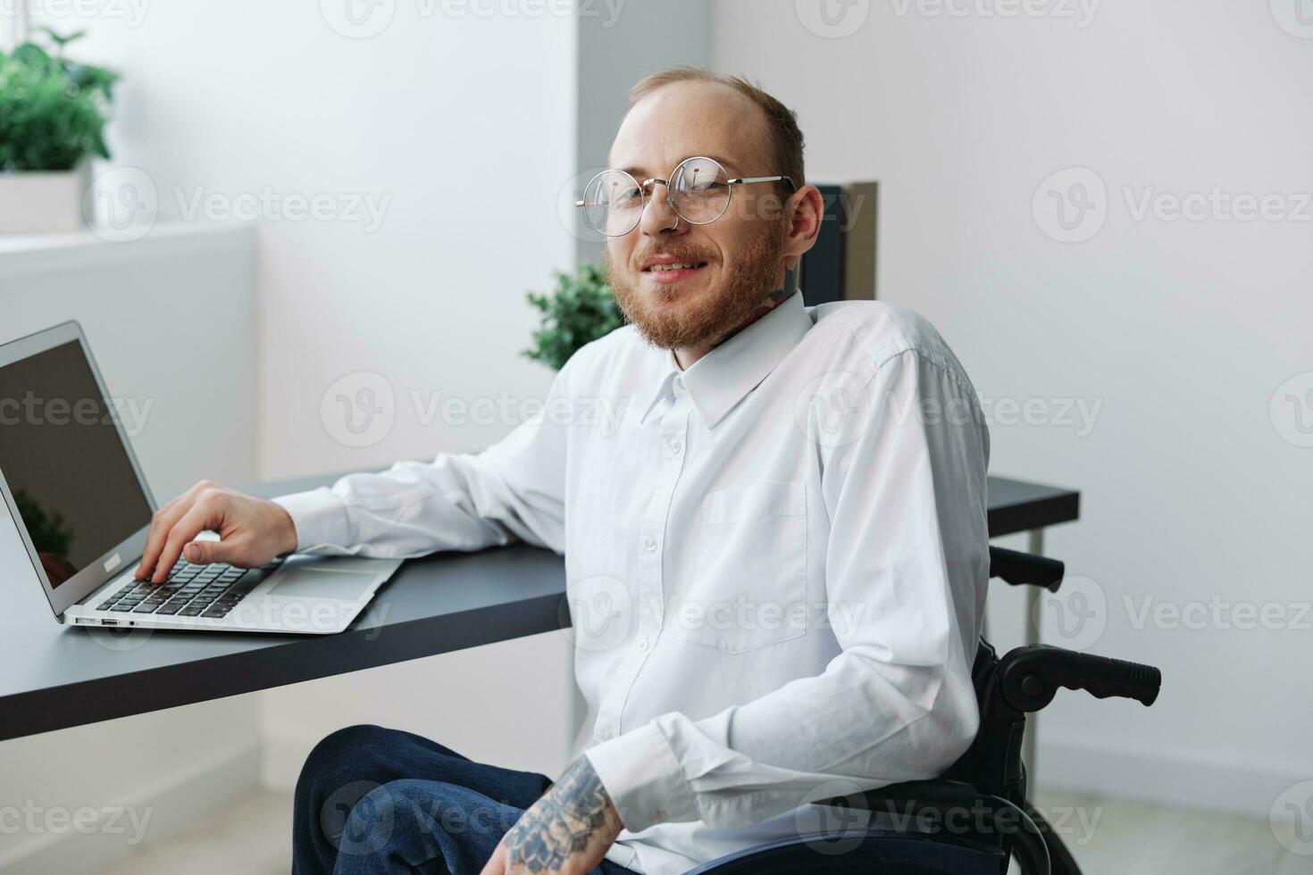 A man wheelchair, businessman in the office working laptop, working online, social networks startup, integration into society, the concept of working a person with disabilities, a real person close-up photo