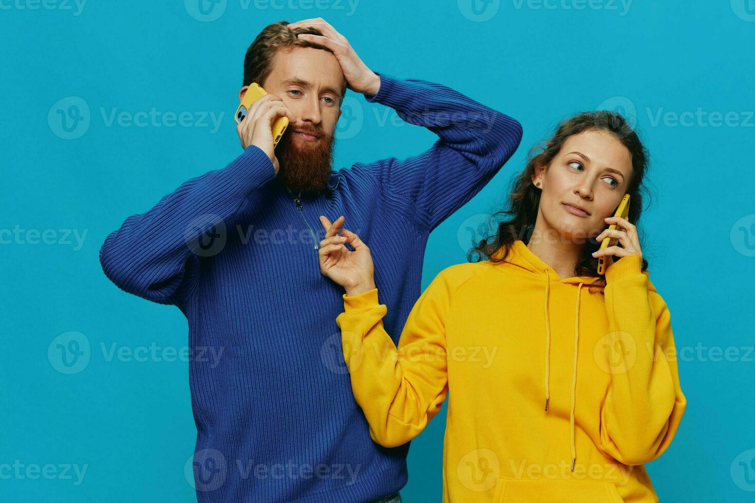 Woman and man cheerful couple with phones in their hands crooked smile cheerful, on blue background. The concept of real family relationships, talking on the phone, work online. photo